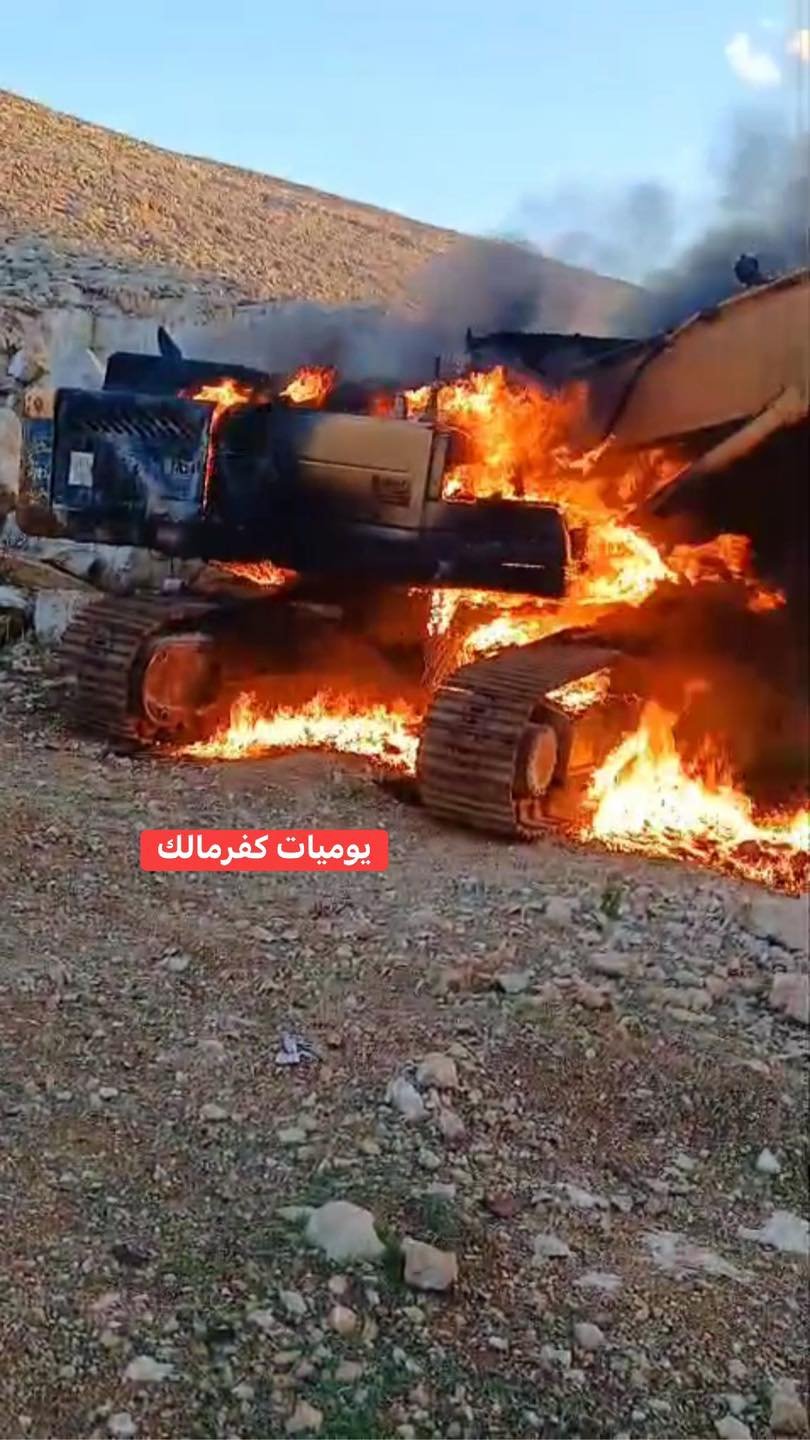 مستوطنون يحرقون "كرفانا" وجرافة ويخطون شعارات عنصرية في كفر مالك 